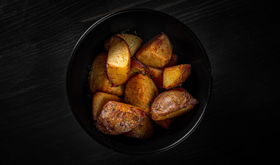 roasted potato in bowl on black wooden table background