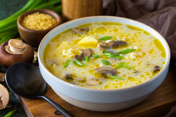 Diet and healthy eating concept. Royal Mushroom cream soup with bulgur on a dark stone background.