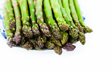 Bunch of fresh raw asparagus on white background, vegetarian concept. Green grass sparrowgrass sticks, food for veggie.