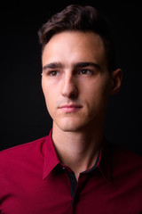 Portrait of young handsome businessman thinking and looking up