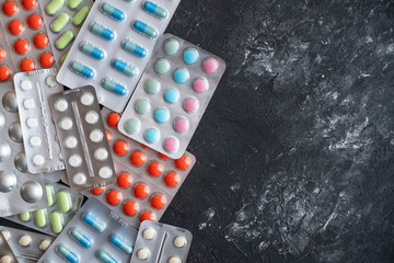 Different pills on dark background with copy space. Top view