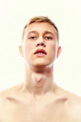 Handsome young shirtless man posing isolated on white. Portrait of a sexy young man with muscular body. Men's health.   