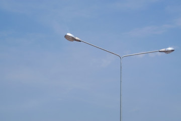 Street lighting bulb in daytime with blue sky close-up.