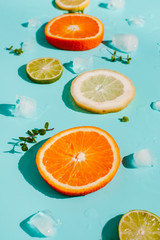 Top view. Citrus with ice on a blue background. Fresh  summer fruits. Copy space.