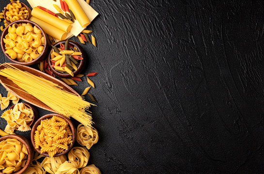 Different pasta types on black background with copy space for text