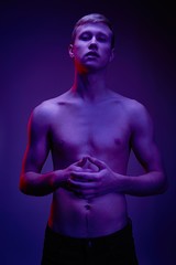 Handsome young shirtless man posing against studio background. Portrait of a sexy young man with muscular body. Men's health.