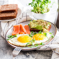 Egg breakfast. Healthy nutritious breakfast with eggs, salmon, avocado sandwich and sprouted pea seeds.