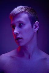 Handsome young shirtless man posing against studio background. Portrait of a sexy young man with muscular body. Men's health.