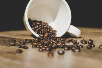 coffee beans in a white cup on an old wooden table