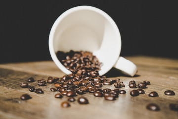 coffee beans in a white cup on an old wooden table