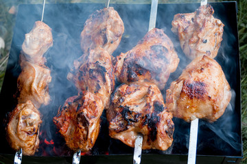 charcoal grilled meat outdoors with smoke.