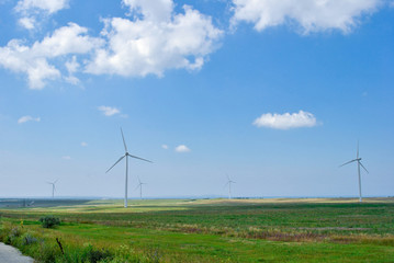 Fototapeta na wymiar several wind generators on the field on a sunny day