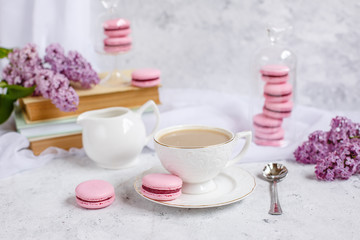 postcard good morning. a Cup of coffee , a branch of lilac, macaroons, old books .