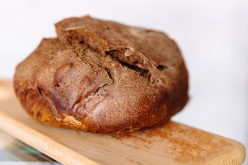Fresh homemade crisp brown bread. Freshly baked bread on wooden cutting board. 