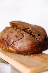 Fresh homemade crisp brown bread. Freshly baked bread on wooden cutting board. 