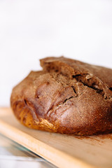 Fresh homemade crisp brown bread. Freshly baked bread on wooden cutting board. 