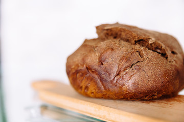 Fresh homemade crisp brown bread. Freshly baked bread on wooden cutting board. 