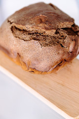 Fresh homemade crisp brown bread. Freshly baked bread on wooden cutting board. 