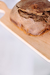 Fresh homemade crisp brown bread. Freshly baked bread on wooden cutting board. 