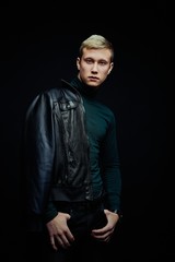 Handsome young man in stylish clothes posing against studio background. portrait of a young man with blond hair and blue eyes.