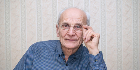 portrait of elderly professor man with glasses in his hands