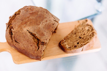 Fresh homemade crisp brown bread. Freshly baked bread on wooden cutting board. 