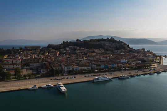 Old town of Nafplion in Greece view from above with tiled roofs, small port and bourtzi castle on the Mediterranean sea water
