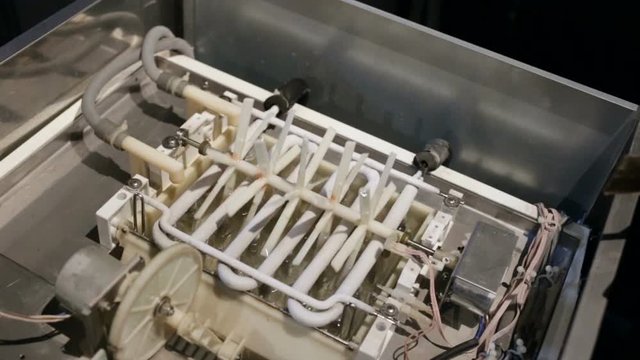 automatic ice-making plant. plastic axis of the agitator rotates, stirring the water. The zigzag metal heat exchanger is covered with frost, and the ice in the tank freezes on the heat exchanger.