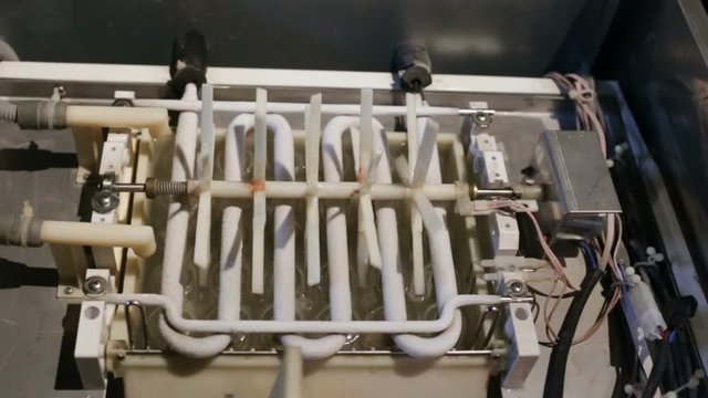 automatic ice-making plant, view from the top down. The plastic agitator rotates. Icy zigzag heat exchanger, ice freezes out of the water in the tray.