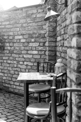 Street view of a empty coffee terrace with tables and chairs in old town. Small depth of field.