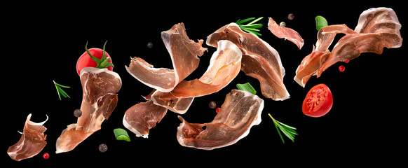 Falling jamon slices, iberian ham isolated on black background