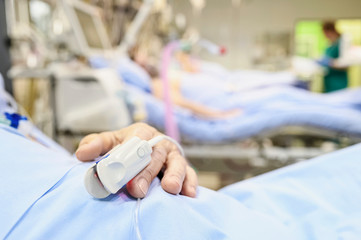 Blood oxymetry probe on a patient hand in intensive care unit.