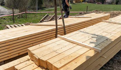 Stack of wooden beams on construction site prepared for building a house