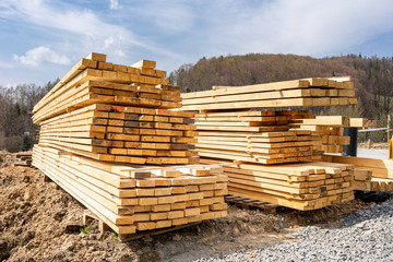 Stack of wooden beams on construction site prepared for building a house