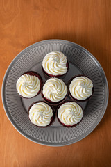 Red velvet cupcakes with white cream on top.