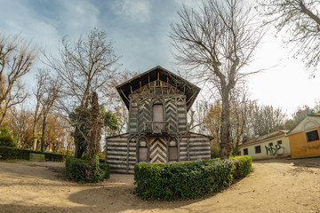 Fototapeta na wymiar Toledo, Spain - Dec 17, 2018: Old wood house, covered by bark surrounded by the bare winter trees in the center of Park La Vega in Toledo city, Spain, Europe
