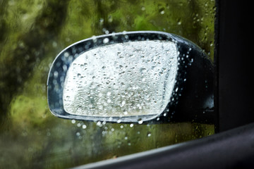 The side mirror of the car in drops of rain