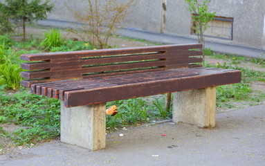 Street brown bench made of wood and concrete