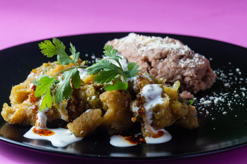 Pork rinds in green salsa with refried beans