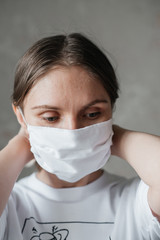 .young girl with short hair in a white t-shirt in a mask, at home, close-up. Coronavirus. Quarantine