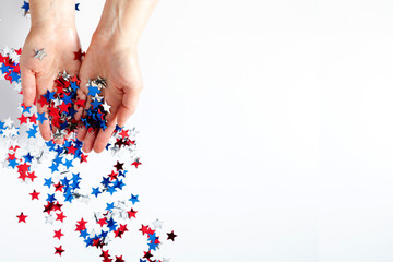 4th of July American Independence Day. Happy Independence Day, Female hands with decorations stars on white background. Flat lay, top view, copy space