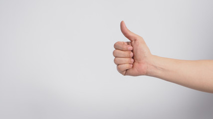 Right hand is doing thumbs up sign on white background.