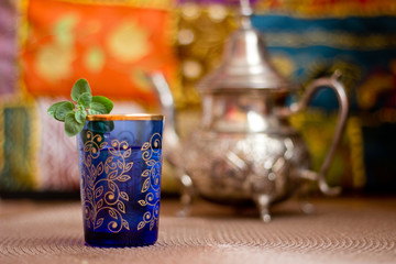 Moroccan tea in a blue glass and a teapot
