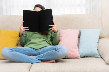 Girl sitting on a couch reading a book