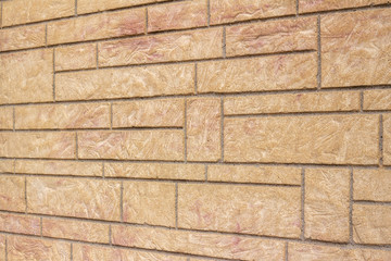 Vintage stone brick wall texture background with pinkish tan color textured surface, showing minor cracks and weathering from age