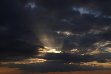 Fototapeta na wymiar Beautiful sunset, rays make their way through heavy clouds.
