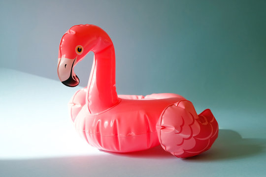 Inflatable pink flamingos on an blue background.