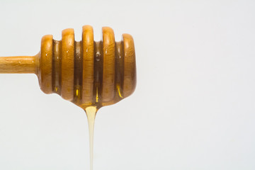 honey dripping from a wooden dipper