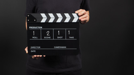 Hand is holding clapper board or movie slate with write in number use in video production and movie...