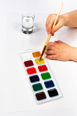 Watercolor paints and brush for drawing. Children's creativity, painting, early development.